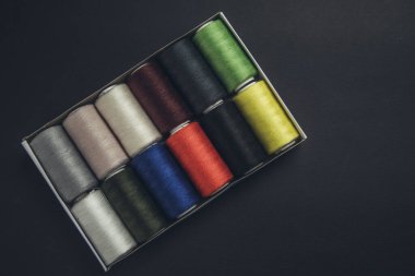 Siyah arkaplan üzerindeki renkli iplik bobinleri