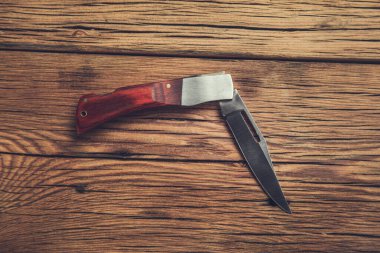 çakı ahşap masa arkasında.