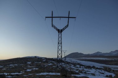 Kışın günbatımında elektrik kulesi