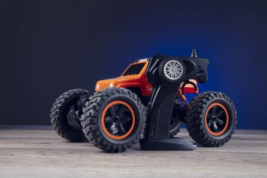 Mavi arkaplanda uzaktan kumanda ve oyuncak araba