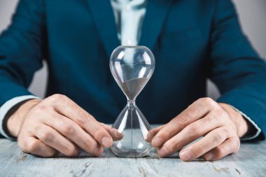 Genç işadamı Han 'ında kum saati tutuyor.