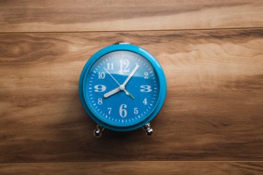 Ahşap masa arkaplanındaki mavi saat