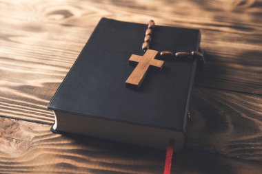 Ahşap arka planda kutsal İncil üzerine ahşap haç