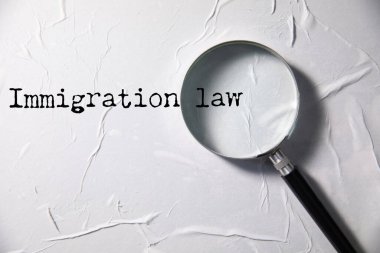 Göçmenlik kelimesi beyaz kağıda kalemle yazılır. İş konsepti. Hukuk, adalet ve hukuk teması