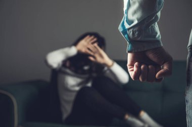 Kızgın adam genç üzgün kadını dövüyor.