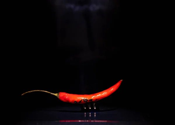 chili pepper on a fork, hot chili pepper close-up