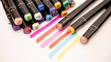 Metin için kopyalama alanı olan beyaz arkaplan üzerindeki renkli işaretleyici kalemler.