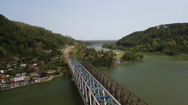 Dağ nehri ve ağaçlar manzaralı demiryolu köprüsünün hava aracı görüntüsü