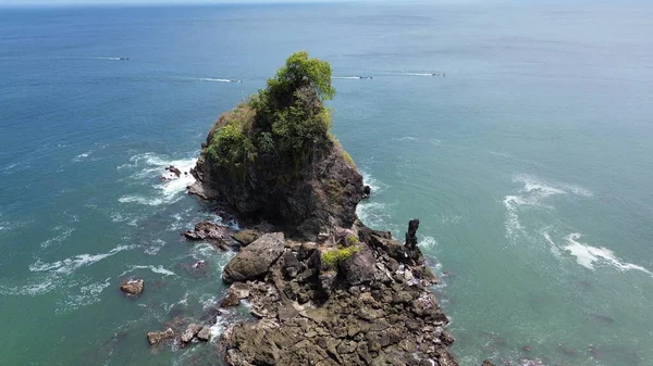 Drone Manzarası Karang Agung Sahili, Kebumen, Central Java, Endonezya 'da kayalıkları, dalgaları ve ağaçları olan plajın güzelliği