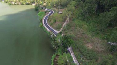 Serayu nehri ve yeşil ormandaki ağaçlar arasındaki otoyolun 4k hava aracı görüntüsü
