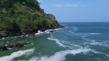 Mercan kayalıkları ve güzel dalgaları olan tropik plajlar, turist ve ziyaretçi olmayan yeşil ağaçlarla birlikte.