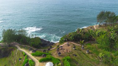 Menganti Sahili, Kebumen, Central Java, Endonezya 'nın insansız hava aracı manzarası, beyaz kum, sakin dalgalar, mercan kayalıkları ve yeşil ağaçlarla dolu güzel sahil.