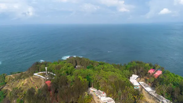 Menganti Sahili, Kebumen, Central Java, Endonezya 'nın insansız hava aracı manzarası, beyaz kum, sakin dalgalar, mercan kayalıkları ve yeşil ağaçlarla dolu güzel sahil.