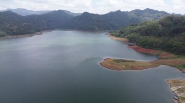 Sempor rezervuar barajının veya Gombong Kebumen 'deki Waduk Sempor, Central Java, Endonezya' daki bulutların, tepelerin ve yeşil ağaçların hava aracı görüntüsü