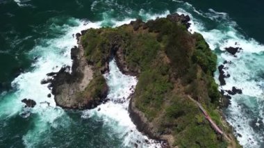 Hava Aracı Manzarası Gebyuran Sahili 'ndeki Tanjung Karang Penganten' in güzelliği, Kebumen, Central Java, Endonezya, güzel mercan kayalıkları, sakin dalgaları, tepeleri ve yeşil ağaçları olan bir sahil.