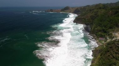 Hava Aracı Manzarası Gebyuran Sahili 'ndeki Tanjung Karang Penganten' in güzelliği, Kebumen, Central Java, Endonezya, güzel mercan kayalıkları, sakin dalgaları, tepeleri ve yeşil ağaçları olan bir sahil.