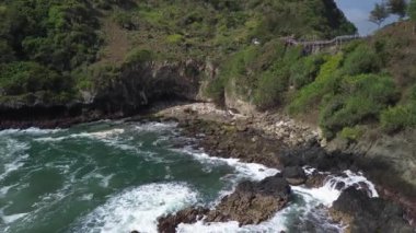 Hava Aracı Manzarası Gebyuran Sahili 'ndeki Tanjung Karang Penganten' in güzelliği, Kebumen, Central Java, Endonezya, güzel mercan kayalıkları, sakin dalgaları, tepeleri ve yeşil ağaçları olan bir sahil.