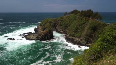 Hava Aracı Manzarası Gebyuran Sahili 'ndeki Tanjung Karang Penganten' in güzelliği, Kebumen, Central Java, Endonezya, güzel mercan kayalıkları, sakin dalgaları, tepeleri ve yeşil ağaçları olan bir sahil.