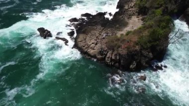 İnsansız hava aracı görüntüsü Gebyuran Sahili 'ndeki Tanjung Karang Penganten güzelliği veya Lampon Sahili, Kebumen, Central Java, Endonezya, güzel mercan kayalıkları, sakin dalgalar, tepeler ve yeşil ağaçlarla dolu bir sahil.