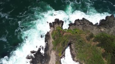 İnsansız hava aracı görüntüsü Gebyuran Sahili 'ndeki Tanjung Karang Penganten güzelliği veya Lampon Sahili, Kebumen, Central Java, Endonezya, güzel mercan kayalıkları, sakin dalgalar, tepeler ve yeşil ağaçlarla dolu bir sahil.