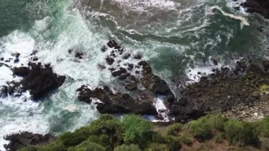 İnsansız hava aracı görüntüsü Gebyuran Sahili 'ndeki Tanjung Karang Penganten güzelliği veya Lampon Sahili, Kebumen, Central Java, Endonezya, güzel mercan kayalıkları, sakin dalgalar, tepeler ve yeşil ağaçlarla dolu bir sahil.