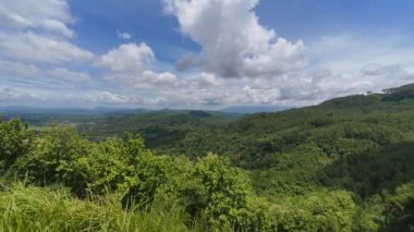Tepenin tepesinden manzaranın zamanı, hareket eden bulutlar, tepeler, ağaçlar ve gölgeli ormanlar