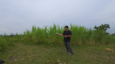 Bir adam Bukit Jerit Kebumen 'de deniz kenarındaki bir platformda İHA uçuruyor.