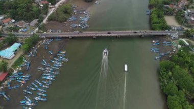 Cilacap ve Kebumen 'i çevreleyen nehir üzerinde geleneksel balıkçı tekneleri ve köprülerin faaliyeti ile manzaralı.