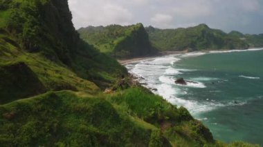 Tepeler, mercan resifleri, dalgalar ve Menganti Sahili, Kebumen, Central Java Endonezya