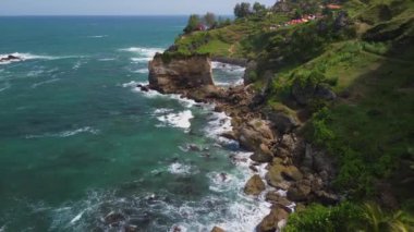 İnsansız hava aracı, Menganti Sahili, Kebumen, Merkez Java, Endonezya 'daki Hint Okyanusu' na komşu mercan resifleri, dalgalar, tepeler ve kamp noktalarıyla deniz manzarası sunar.