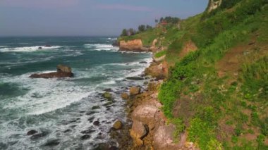 Deniz kenarındaki yeşil tepeleri, Menganti Sahili 'ndeki deniz manzarası ve mercan resifleri, Kebumen.