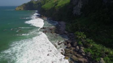 Deniz manzaralı güzel tepeler, yeşil ağaçlar, mercan kayaları, dalgalar ve okyanuslar.