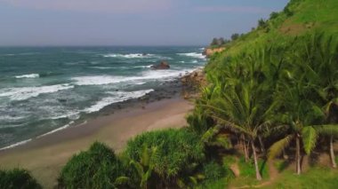 Menganti Sahili 'nin güzelliğinin drone görüntüsü, deniz manzaralı Kebumen tepeler, kayalar ve dalgalarla çevrili.