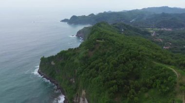 Jerit Hill Kebumen Endonezya 'sındaki tepeler, uçurumlar, ağaçlar ve dalgalarla hava aracı görüntüsü