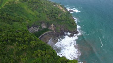 Jerit Hill Kebumen Endonezya 'nın insansız hava aracı manzarası, güzel tepeleri, yeşil ağaçları, mercan kayaları, dalgaları ve okyanusları olan deniz kıyısı.