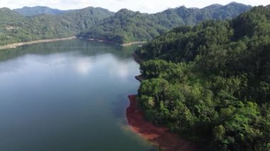 Sempor Reservoir, Kebumen, Central Java, Endonezya manzarası. Etrafında tepeler ve yemyeşil ağaçlardan oluşan berrak suları var.