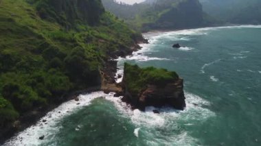 Menganti Beach Kebumen, Central Java, Endonezya 'daki verimli ağaçlarla çevrili kıyı şeridinin insansız hava aracı görüntüsü.