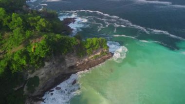 Tepeleri ve ağaçları olan kıyı şeridinin hava aracı görüntüsü, Sawangan Beach Kebumen Central Java Endonezya 'daki deniz dalgaları ile mercan kayalıkları ve deniz manzarası