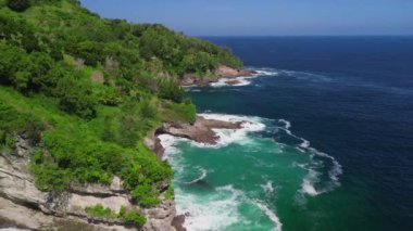 Tepeleri ve ağaçları olan kıyı şeridinin hava aracı görüntüsü, Sawangan Beach Kebumen Central Java Endonezya 'daki deniz dalgaları ile mercan kayalıkları ve deniz manzarası