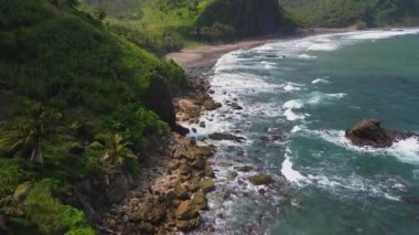 Tepeleri ve ağaçları olan kıyı şeridinin hava aracı görüntüsü, Sawangan Beach Kebumen Central Java Endonezya 'daki deniz dalgaları ile mercan kayalıkları ve deniz manzarası