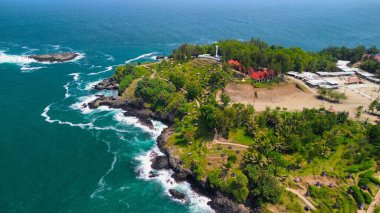 Tepeleri ve ağaçları olan kıyı şeridinin hava aracı görüntüsü, aynı zamanda mercan kayalıkları ve okyanus manzarası Menganti Beach Kebumen Central Java Endonezya 'da.
