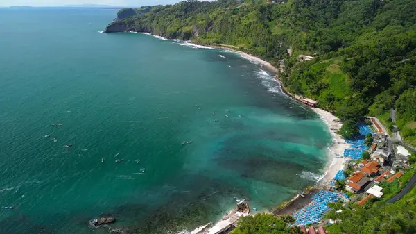 Tepeleri ve ağaçları olan kıyı şeridinin hava aracı görüntüsü, aynı zamanda mercan kayalıkları ve okyanus manzarası Menganti Beach Kebumen Central Java Endonezya 'da.