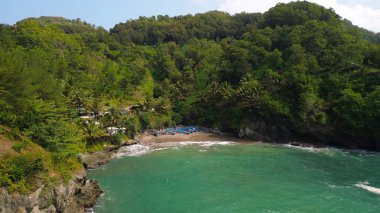 Tepeleri ve ağaçları olan kıyı şeridinin hava aracı görüntüsü, mercan kayalıkları ve deniz manzarası, Lampon Beach Kebumen Central Java Endonezya 'daki okyanus dalgaları.