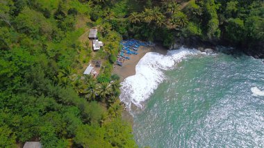 Tepeleri ve ağaçları olan kıyı şeridinin hava aracı görüntüsü, mercan kayalıkları ve deniz manzarası, Lampon Beach Kebumen Central Java Endonezya 'daki okyanus dalgaları.
