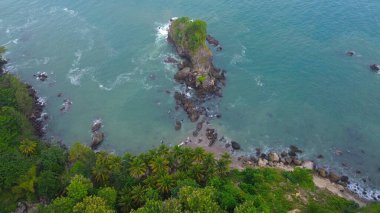 Karang Agung Sahili, Kebumen, Central Java, Endonezya 'daki kayalar, tepeler, ağaçlar, kumsal kumsalları ve dalgalarla kıyı şeridinin insansız hava aracı görüntüsü.