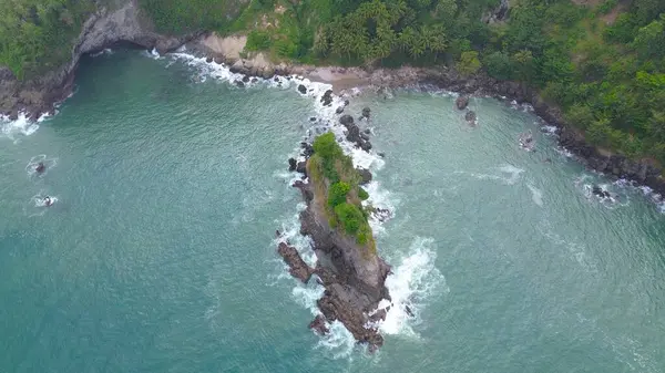 Karang Agung Sahili, Kebumen, Central Java, Endonezya 'daki kayalar, tepeler, ağaçlar, kumsal kumsalları ve dalgalarla kıyı şeridinin insansız hava aracı görüntüsü.