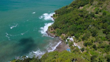 Tepeler, ağaçlar, kayalıklar, mercan resifleri ve Surumanis Sahili, Kebumen, Central Java 'daki denizden gelen dalgalarla birlikte kuş bakışı kıyı şeridi manzarası