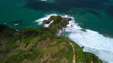 Tepeler, ağaçlar, kayalıklar, mercan resifleri ve Surumanis Sahili, Kebumen, Central Java 'daki denizden gelen dalgalarla birlikte kuş bakışı kıyı şeridi manzarası