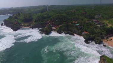 Beyaz kum, mercan kayaları, ağaçlı tepeler, Mbuluk Plajı Gunung Kidul Yogyakarta olarak bilinen okyanustan gelen dalgalar...