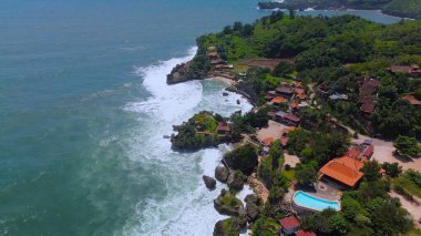 Beyaz kum, mercan kayaları, ağaçlı tepeler, Mbuluk Plajı Gunung Kidul Yogyakarta olarak bilinen okyanustan gelen dalgalar...